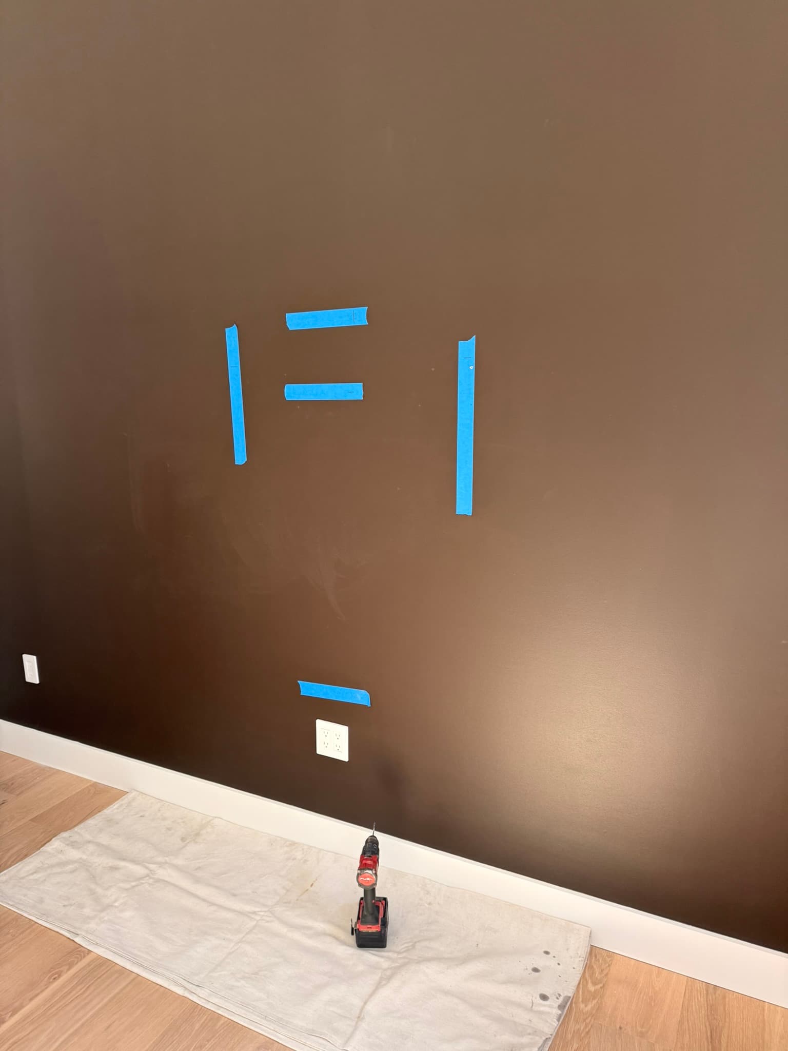 We like to use blue masking tape to layout the TV mounting so as not to damage or mark up the finished paint. These marks are where the studs were, the end goal height of the tv, and the height of the mounting bracket.
